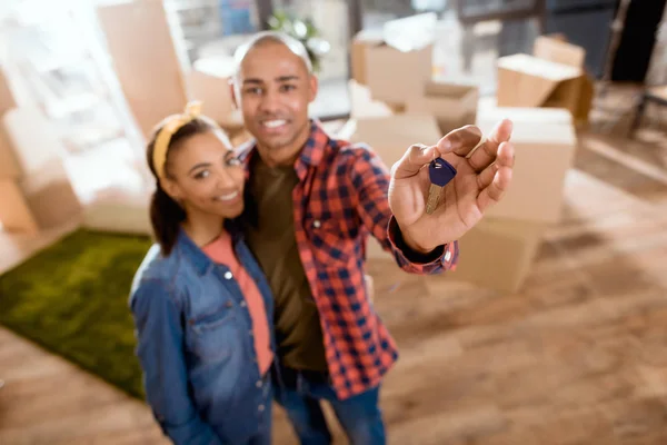 Foco seletivo do casal afro-americano abraçando e segurando chaves da nova casa — Fotografia de Stock