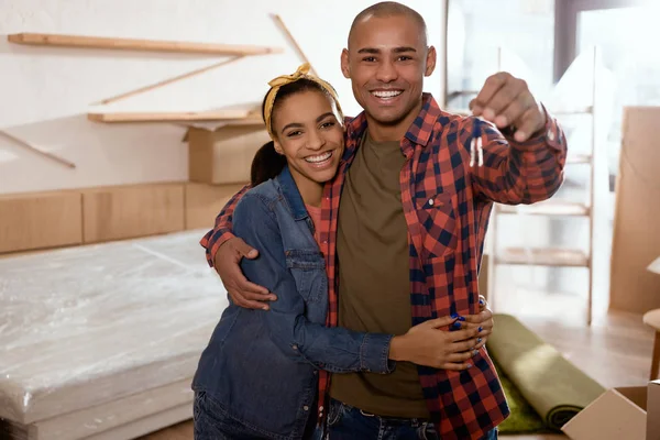Feliz casal afro-americano segurando chaves no novo apartamento — Fotografia de Stock