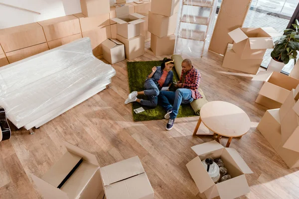 Feliz pareja afroamericana en nuevo apartamento con cajas de cartón - foto de stock