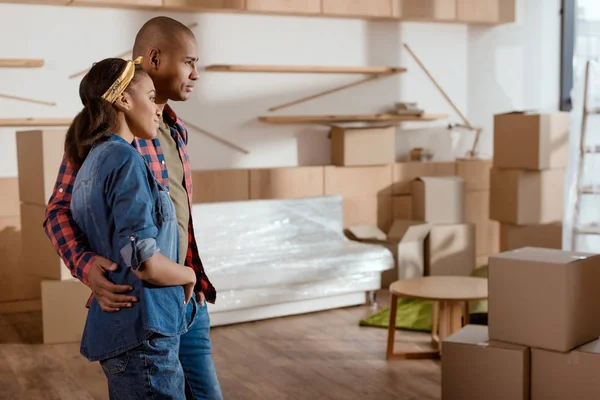 Africano casal americano olhando para casa nova com caixas de papelão — Fotografia de Stock