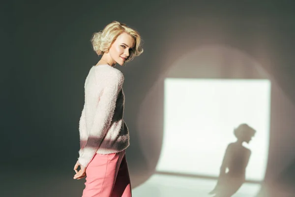 Beautiful blonde girl smiling at camera while posing in studio — Stock Photo