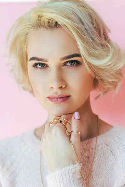 Portrait de belle fille blonde avec des bijoux regardant caméra isolée sur rose — Photo de stock