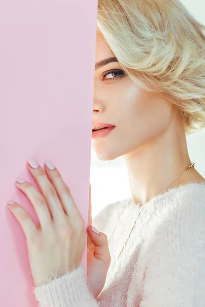 Belle fille blonde avec bannière rose regardant la caméra sur gris — Photo de stock