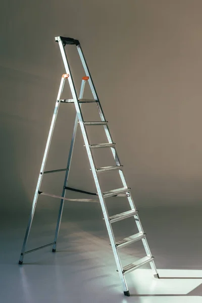 Abrir escada metálica em estúdio em cinza — Fotografia de Stock