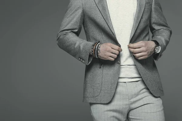 Vista recortada de hombre de negocios en traje gris, aislado en gris - foto de stock