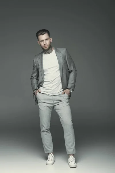 Schöner eleganter Geschäftsmann im grauen Anzug, isoliert auf grau — Stockfoto