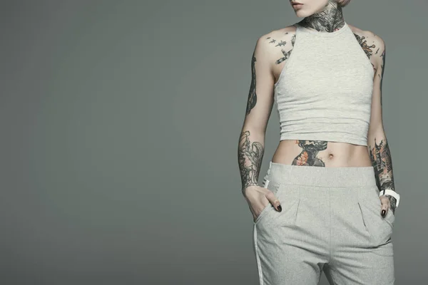 Attractive tattooed girl in sportswear, isolated on grey — Stock Photo