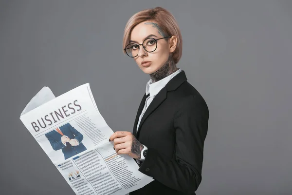 Femme d'affaires en lunettes et costume lecture journal d'affaires, isolé sur gris — Photo de stock