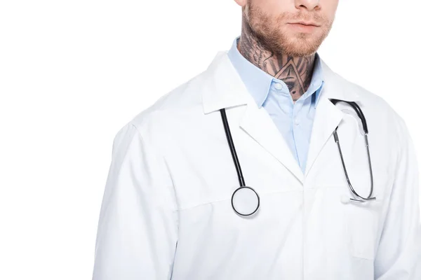 Vista recortada del médico tatuado en bata blanca con estetoscopio, aislado en blanco - foto de stock