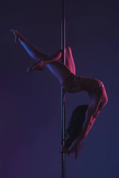 Ansicht der schönen verführerischen flexiblen Frau, die mit der Stange auf blau trainiert — Stockfoto