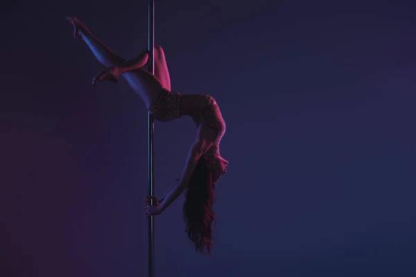 Hermosa chica flexible sensual haciendo ejercicio con polo en azul - foto de stock