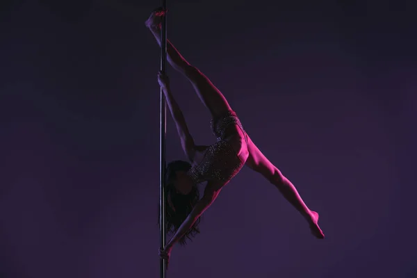 Piena lunghezza di atletica flessibile giovane donna che si esercita con palo su blu — Foto stock