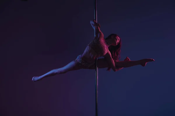 Vista completa de hermosa chica flexible bailando con poste en azul - foto de stock