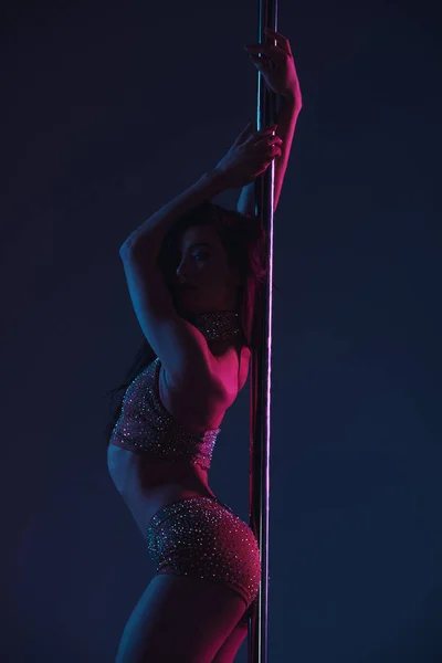 Beautiful seductive young woman posing with pole on blue — Stock Photo