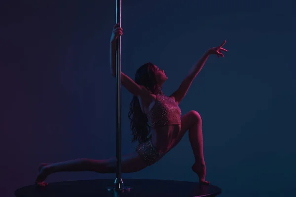 Flexible jeune femme dansant avec poteau sur bleu — Photo de stock