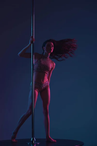 Beautiful sporty girl dancing with pole on blue — Stock Photo
