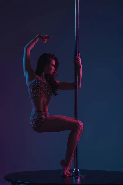 Sensual sporty girl dancing with pole on blue — Stock Photo