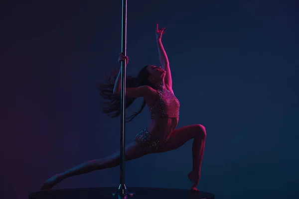 Attractive sporty girl dancing with pole on blue — Stock Photo