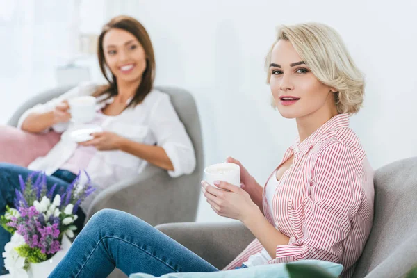 Selective focus of women with coffee cups spending time together — Stock Photo