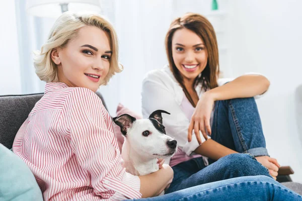 Beautiful smiling girls with jack russell terrier dog at home — Stock Photo