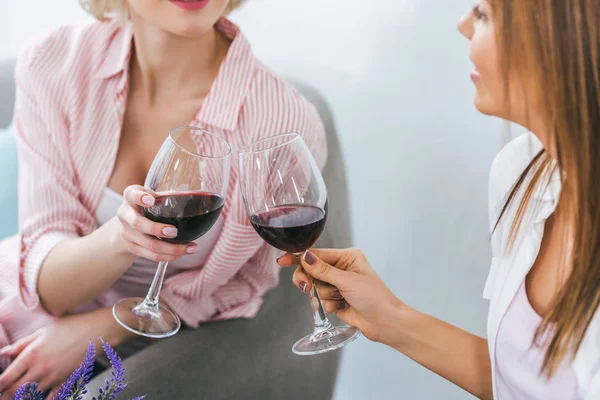 Cropped view of girls clinking with wineglasses and spending time together — Stock Photo