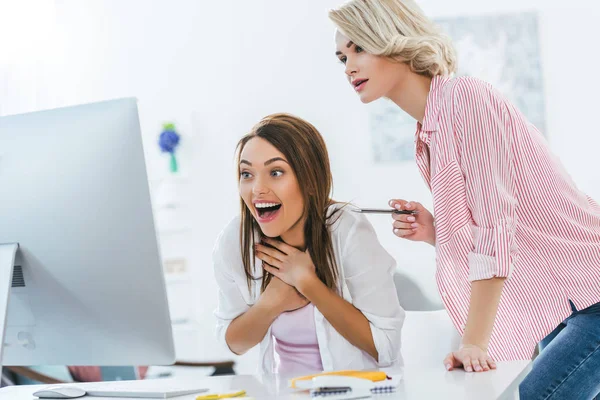 Beautiful excited girls working with computer at home — Stock Photo