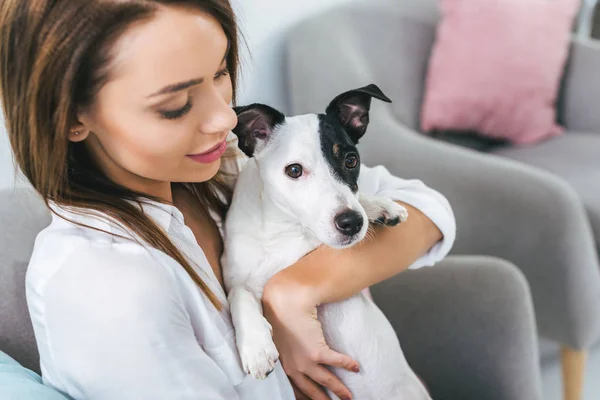 Schöne Frau mit Jack Russell Terrier Hund sitzt auf Sofa — Stockfoto