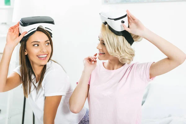 Chicas hermosas usando auriculares de realidad virtual en casa - foto de stock