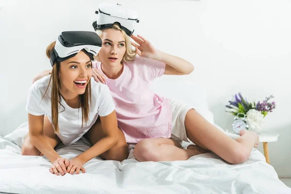 Belles filles s'amuser avec des casques de réalité virtuelle à la maison — Photo de stock