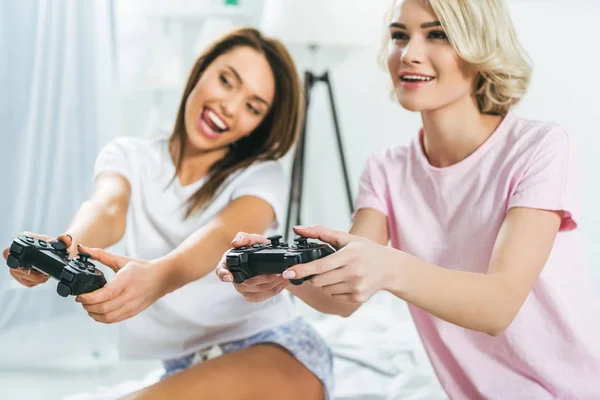 Amigos femeninos palying vigeo juego con joysticks - foto de stock