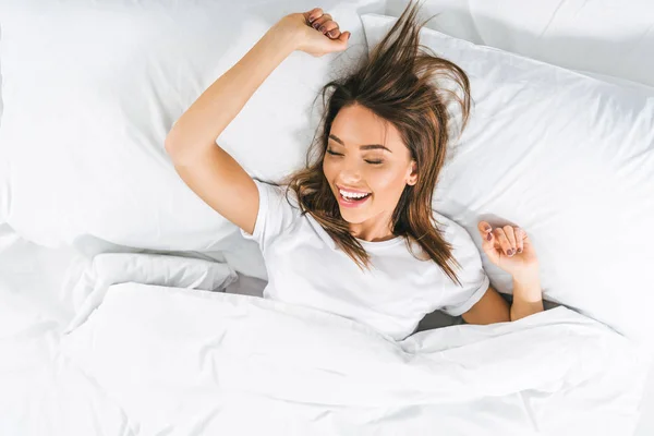 Top view of beautiful girl with closed eyes relaxing in bed — Stock Photo