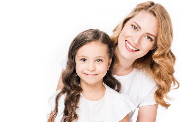 Porträt von lächelnder Mutter und Tochter, die isoliert auf weiß in die Kamera schauen — Stockfoto