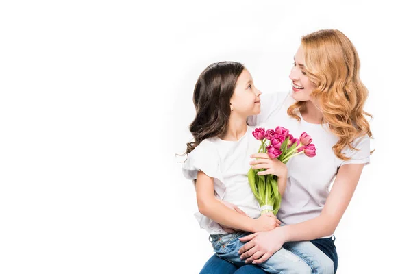 Feliz madre e hija pequeña con ramo de flores aisladas en blanco, madre día concepto de vacaciones - foto de stock