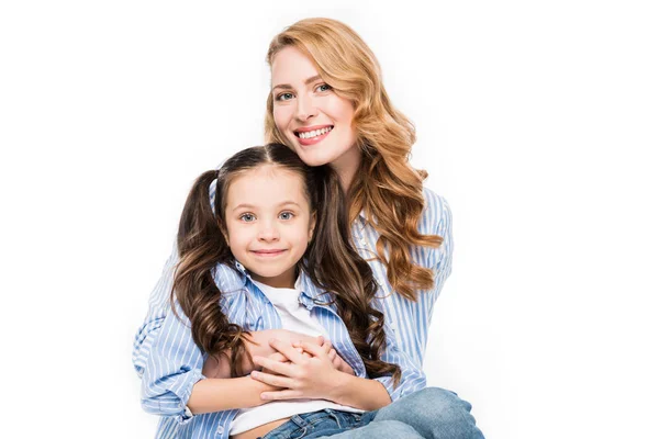 Портрет улыбающейся матери, обнимающей маленькую дочь, изолированную на белом — стоковое фото