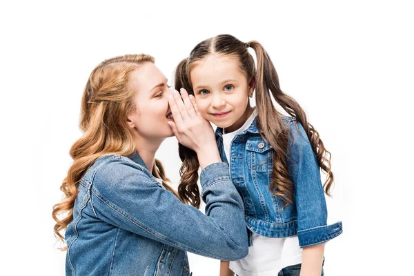 Mãe dizendo segredo para a pequena filha isolada no branco — Fotografia de Stock