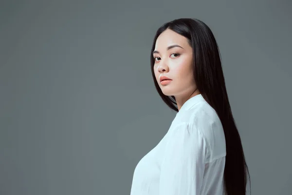 Portrait of beautiful asian girl looking at camera isolated on grey — Stock Photo