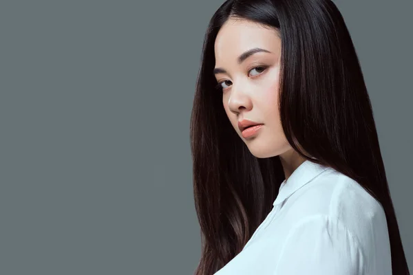 Primer plano retrato de hermosa asiática chica mirando cámara aislada en gris - foto de stock
