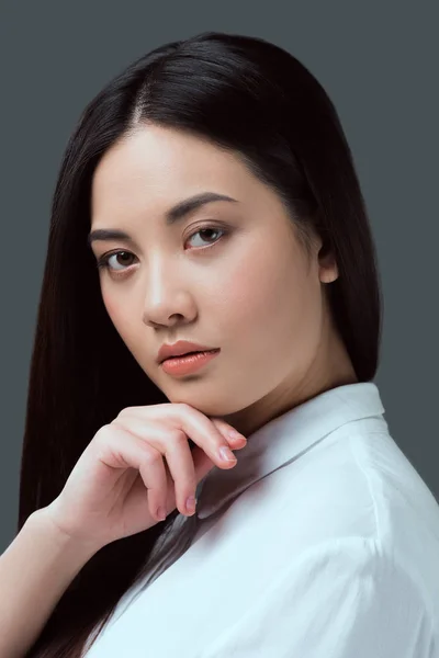Портрет красивої молодої азіатки, дивлячись на камеру ізольовано на сірому — стокове фото