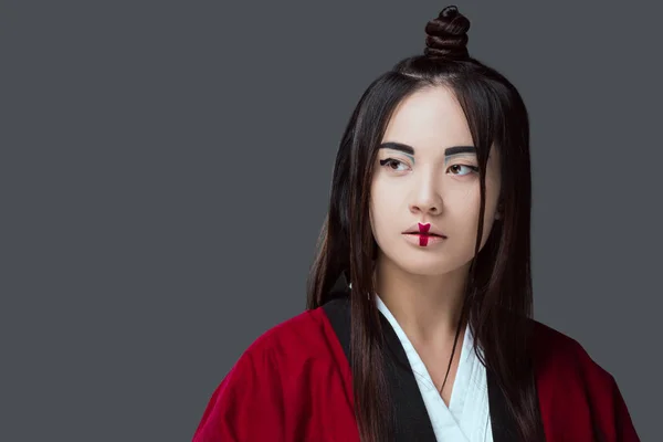 Schöne asiatische Mädchen im Kimono suchen weg isoliert auf grau — Stockfoto