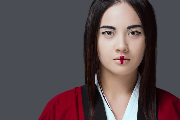 Nahaufnahme Porträt der schönen jungen asiatischen Frau im Kimono, die isoliert auf grau in die Kamera blickt — Stockfoto