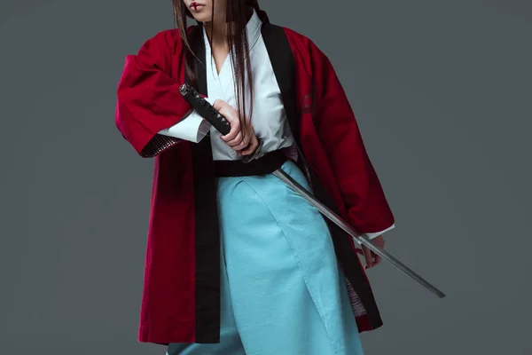 Cropped shot of samurai in kimono holding katana sword isolated on grey — Stock Photo