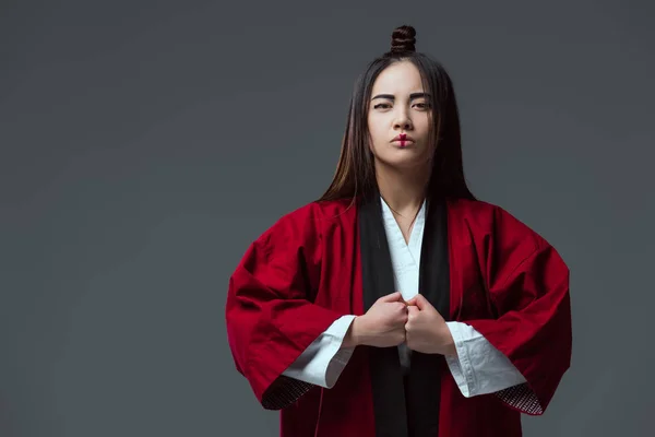 Serious asian woman in traditional japanese kimono looking at camera isolated on grey — Stock Photo