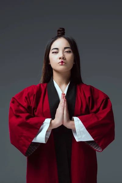 Joven asiático mujer en kimono mirando cámara aislado en gris - foto de stock