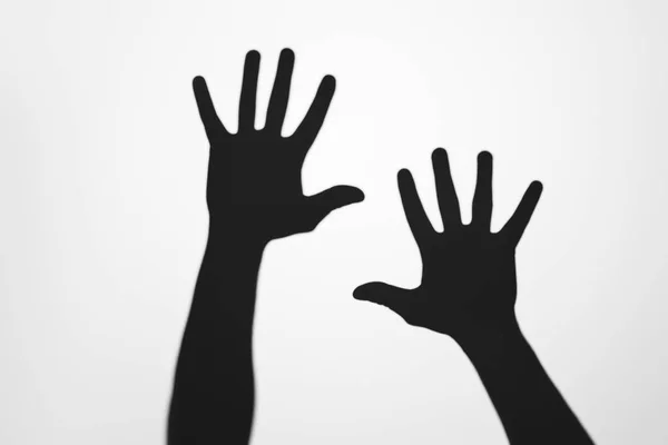 Mysterious shadows of human hands on grey — Stock Photo