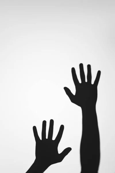 Ombres mystérieuses effrayantes des mains humaines sur le gris — Photo de stock