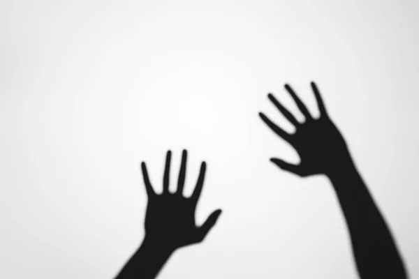 Espeluznantes sombras misteriosas de manos humanas sobre gris - foto de stock