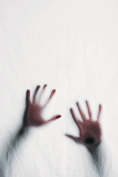 Blurry silhouette of human hands touching frosted glass — Stock Photo