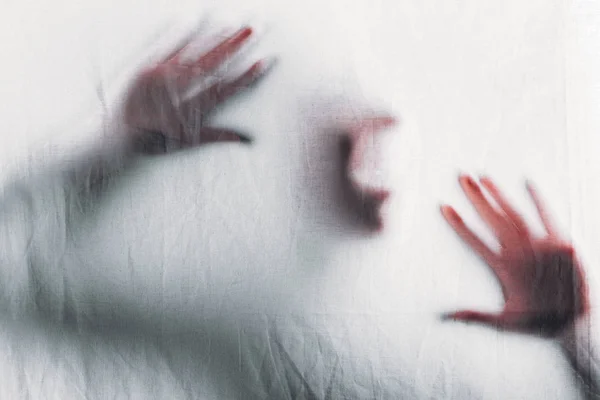 Scary blurry silhouette of unrecognizable person screaming behind veil — Stock Photo