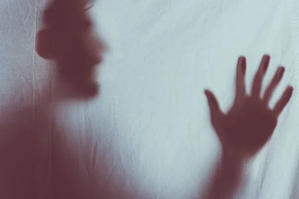Gruselig verschwommene Silhouette einer unkenntlichen Person, die hinter Schleier schreit — Stockfoto