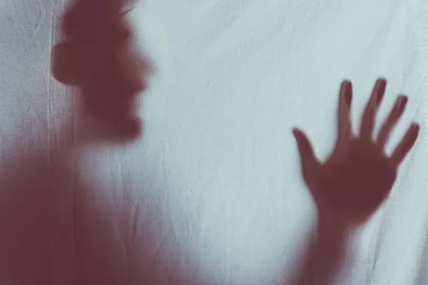 Scary blurry silhouette of unrecognizable person screaming behind veil — Stock Photo